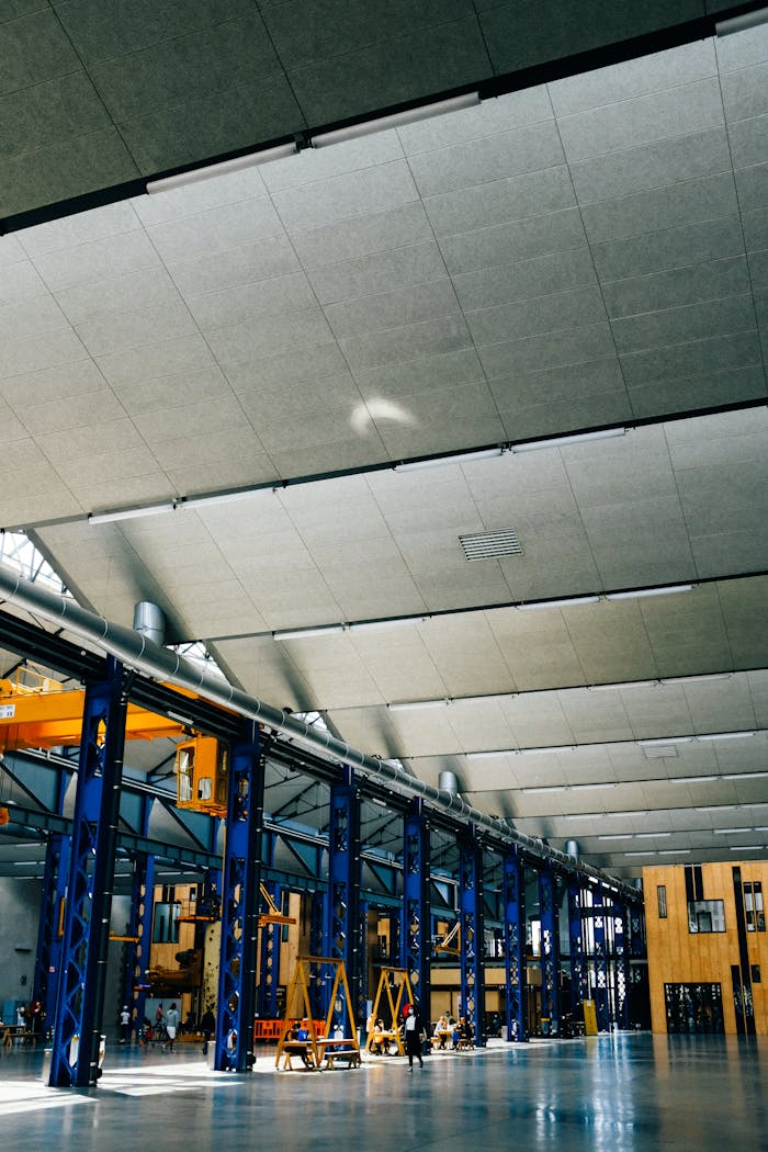 Spacious indoor warehouse with steel beams and machinery, ideal for industrial applications.